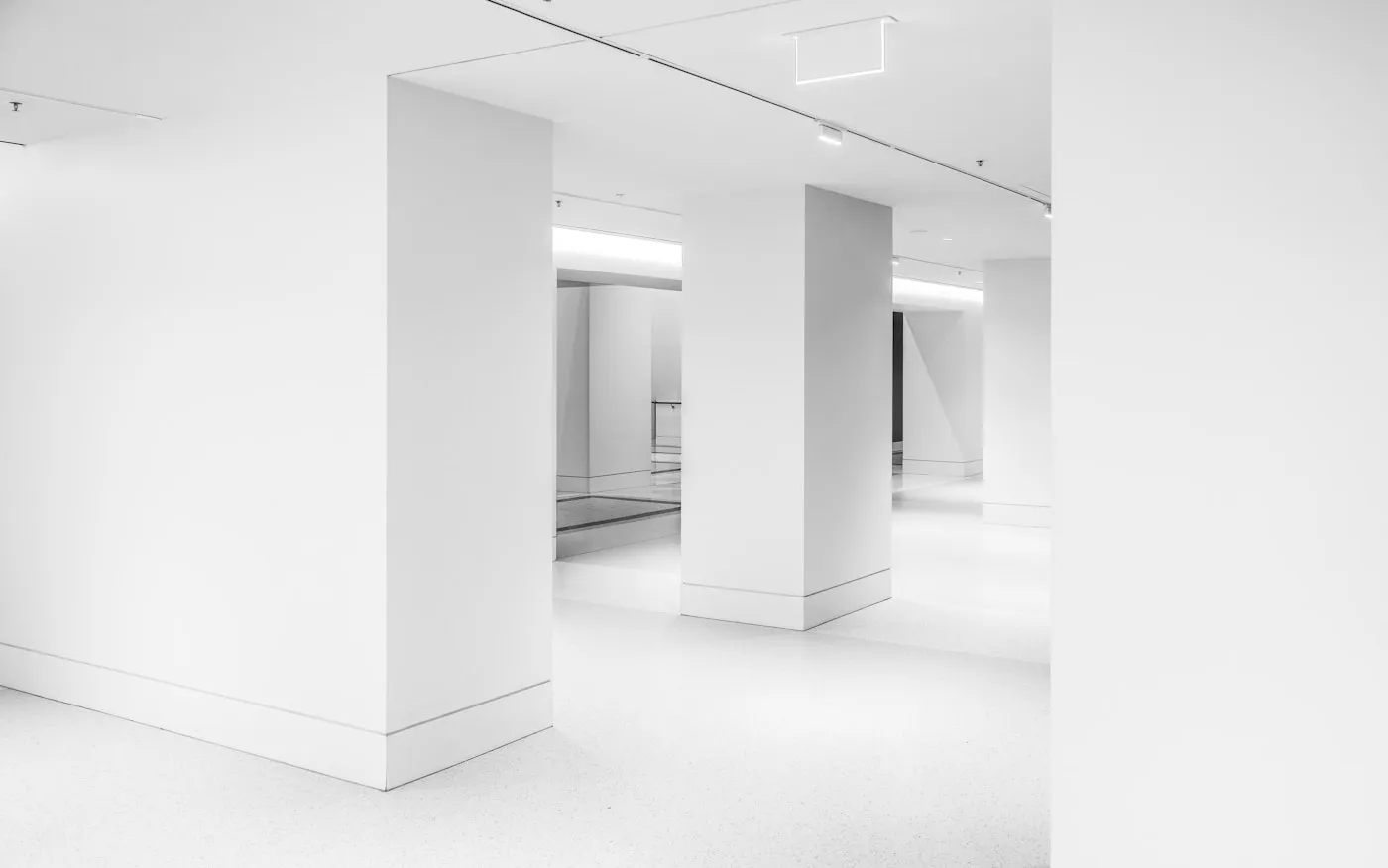 A clean, empty white interior with structural pillars