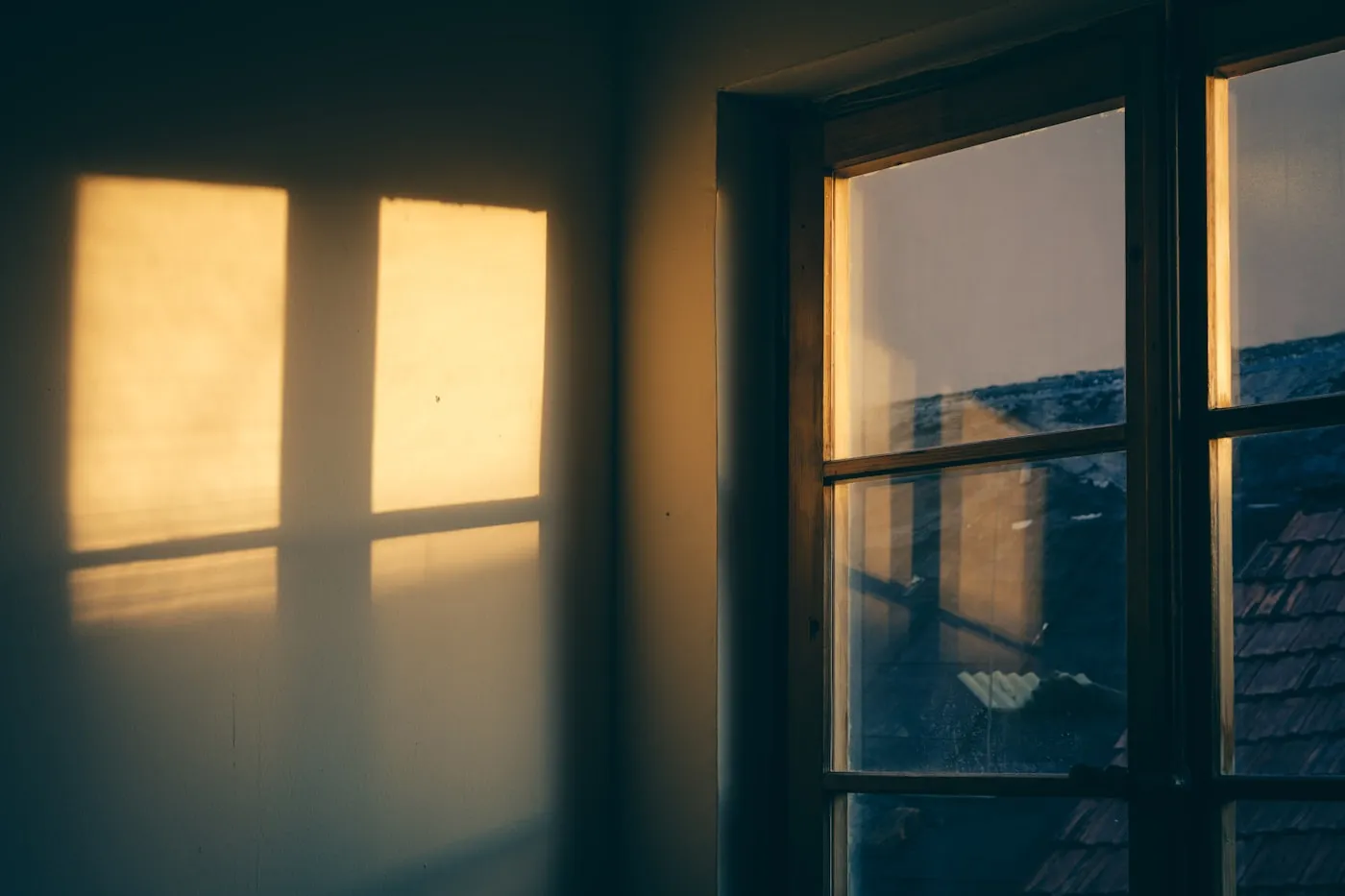 Late afternoon sunlight falling through a window onto a plain wall