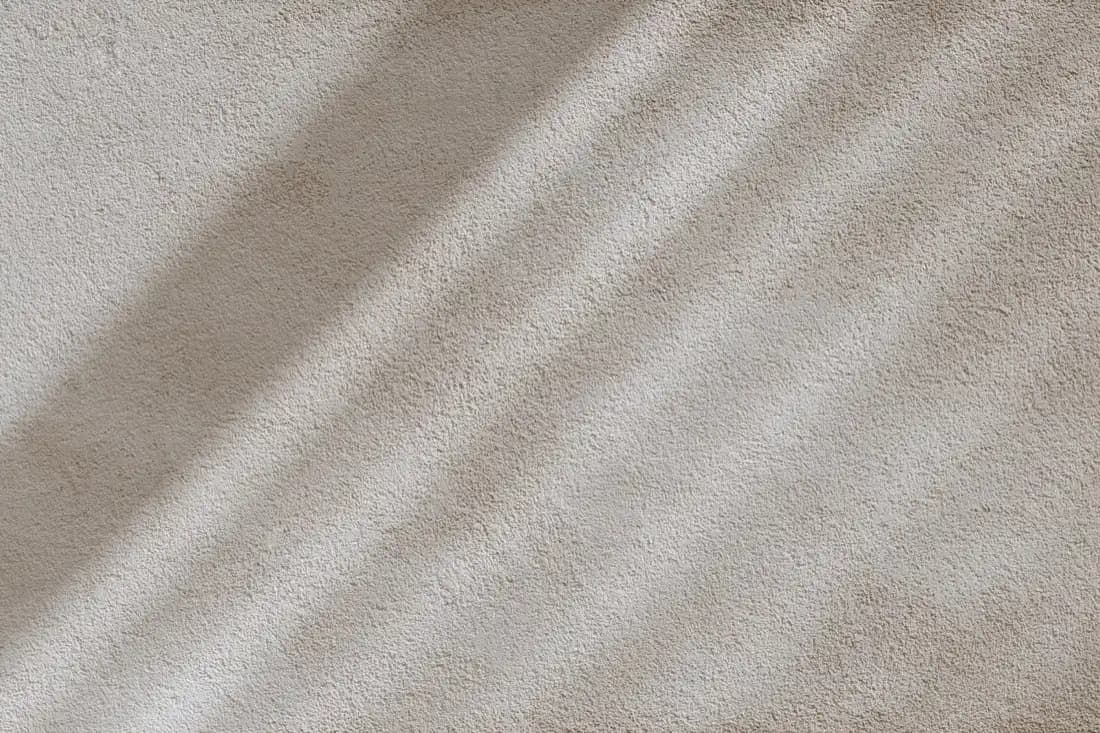 Soft daylight and shadow falling across a pale textured surface